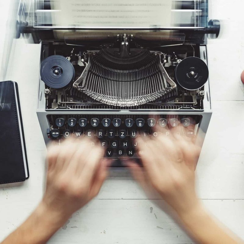 Writer typing with retro writing machine.